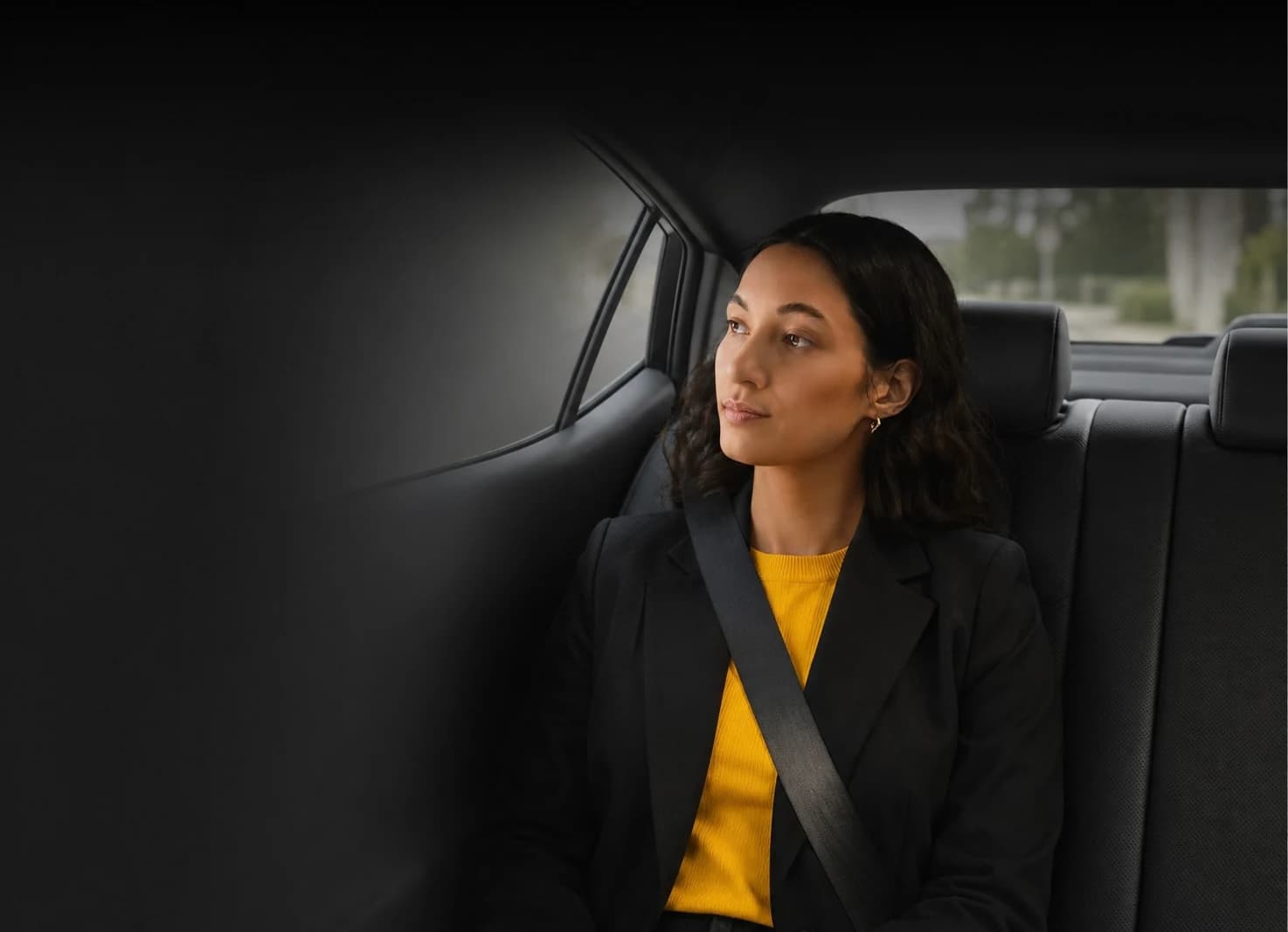Passagère assise à l'arrière d'un véhicule, ceinture de sécurité attachée